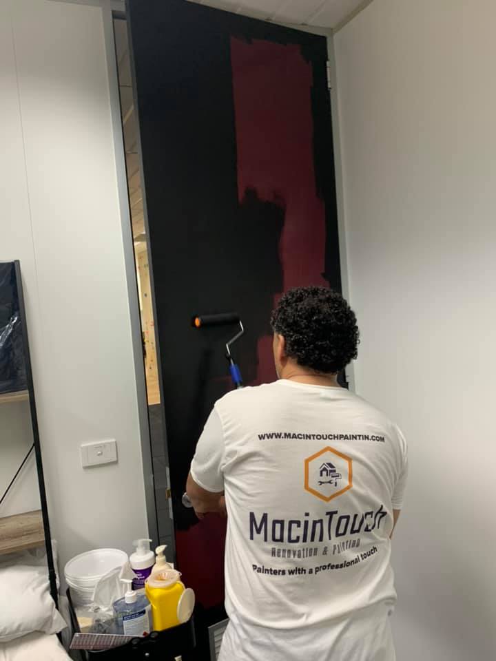 Macintouch worker doing paint job on the door, painting services near me