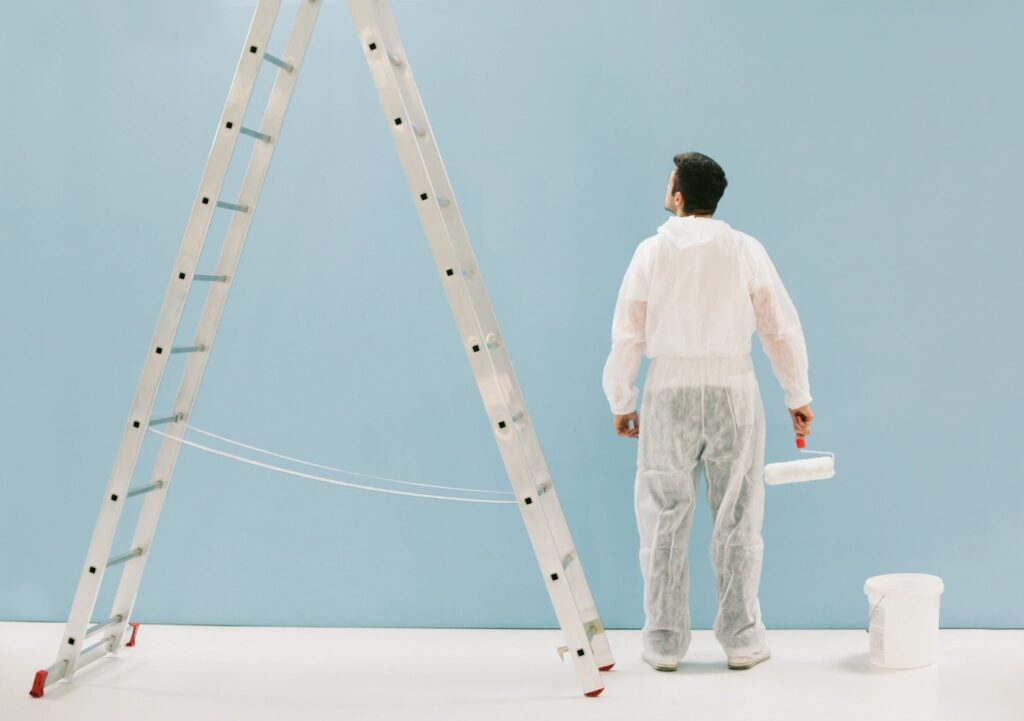 Painting workers looking at blue painted wall