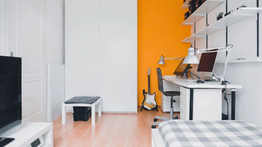 Classic design combination small bedroom and its work space with white and orange painted walls